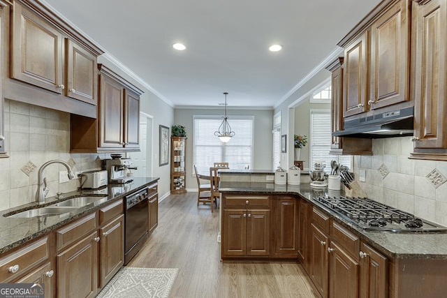 kitchen featuring sink, stainless steel gas cooktop, dark stone countertops, dishwasher, and pendant lighting