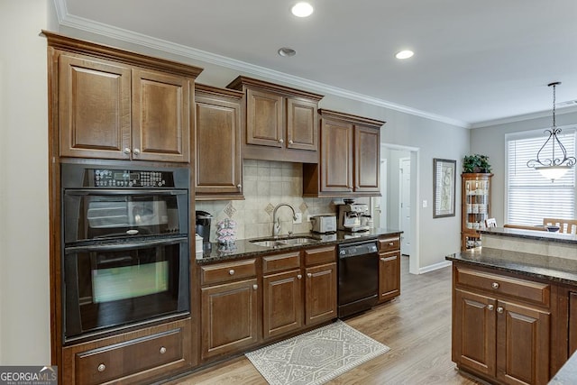 kitchen with sink, light hardwood / wood-style flooring, dark stone countertops, ornamental molding, and black appliances