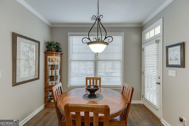 dining room featuring dark hardwood / wood-style flooring, a wealth of natural light, and ornamental molding