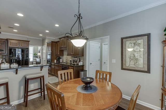 dining area featuring dark wood-type flooring and ornamental molding