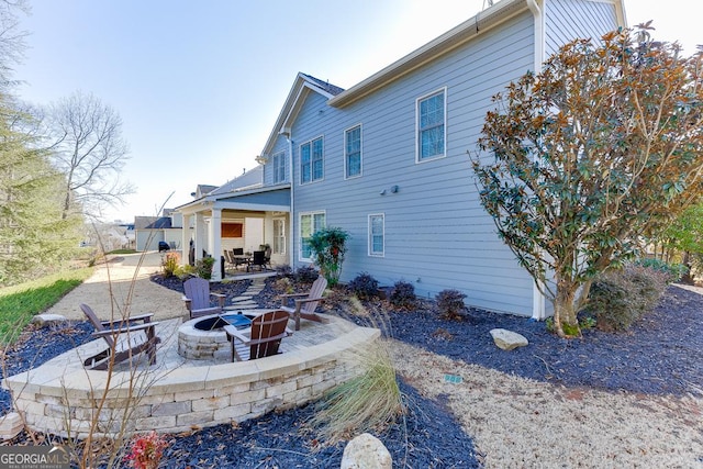 rear view of house with an outdoor fire pit and a patio area