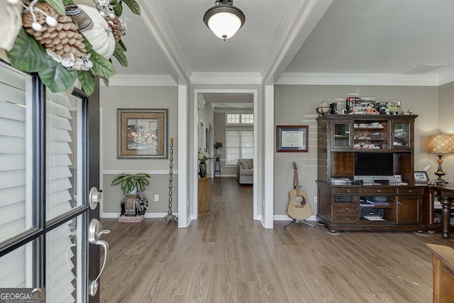 entrance foyer featuring ornamental molding and light hardwood / wood-style flooring