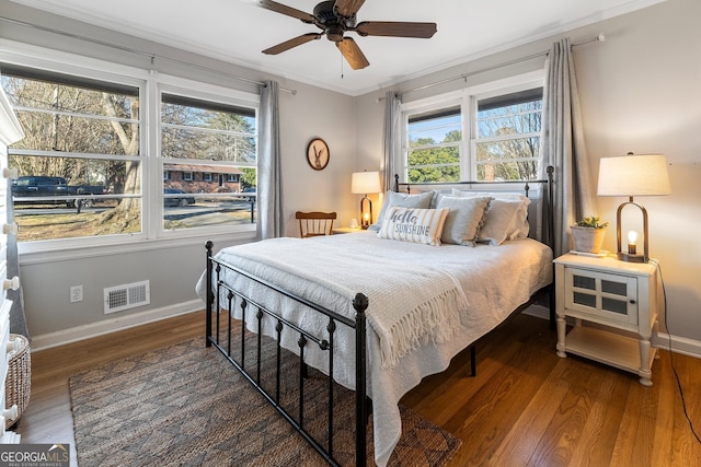 bedroom with multiple windows, crown molding, dark hardwood / wood-style flooring, and ceiling fan