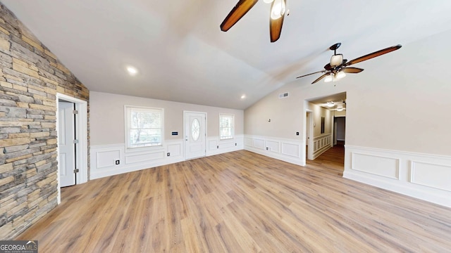 unfurnished living room featuring ceiling fan, vaulted ceiling, and light wood-type flooring