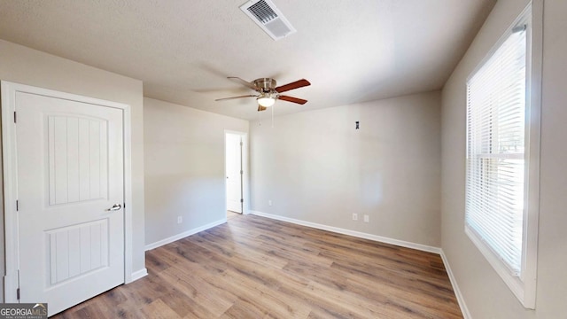 spare room featuring ceiling fan, a textured ceiling, and light wood-type flooring