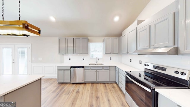 kitchen featuring sink, gray cabinets, appliances with stainless steel finishes, backsplash, and light wood-type flooring