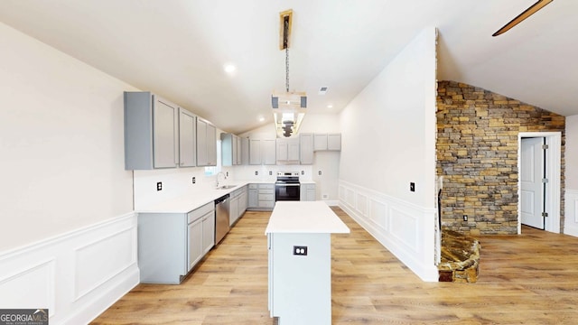 kitchen featuring lofted ceiling, gray cabinetry, a center island, appliances with stainless steel finishes, and pendant lighting