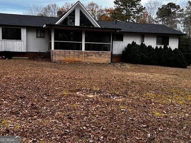 view of front of house with a sunroom and a chimney