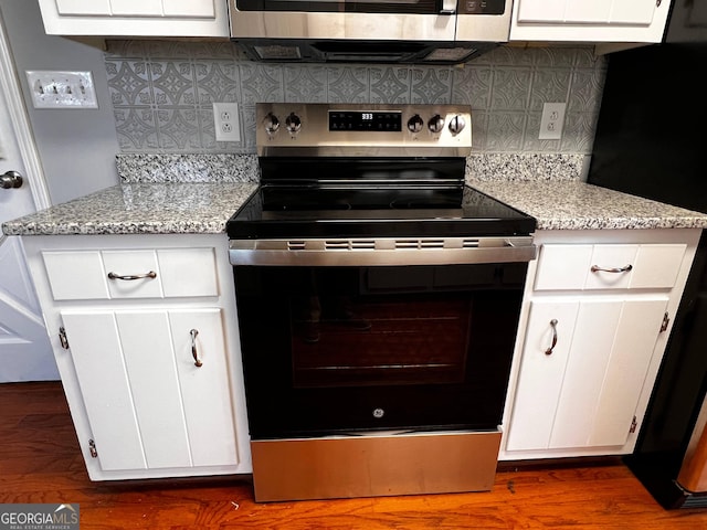 kitchen featuring dark wood-style flooring, backsplash, electric range oven, white cabinets, and fridge