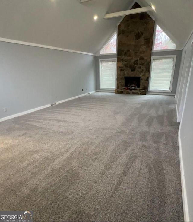 unfurnished living room with beamed ceiling, a fireplace, high vaulted ceiling, and carpet