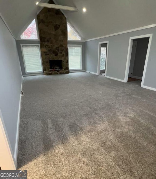 unfurnished living room with high vaulted ceiling, a fireplace, and carpet floors