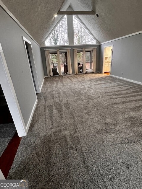 unfurnished living room featuring baseboards, a textured ceiling, carpet flooring, high vaulted ceiling, and beam ceiling