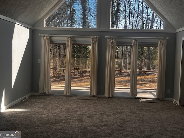 entryway featuring high vaulted ceiling, carpet flooring, and baseboards