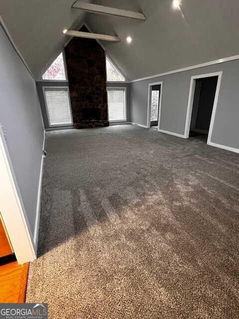 unfurnished living room featuring carpet floors and high vaulted ceiling