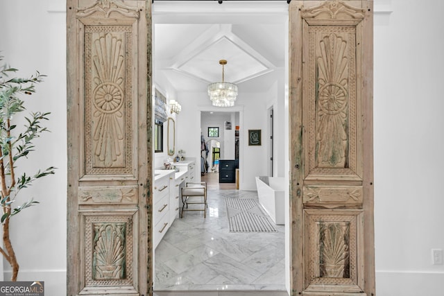 bathroom featuring vanity, coffered ceiling, a bath, and a notable chandelier