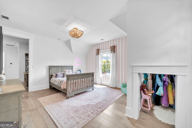 bedroom with lofted ceiling and light hardwood / wood-style flooring