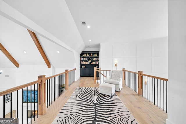 living area featuring lofted ceiling with beams and light wood-type flooring