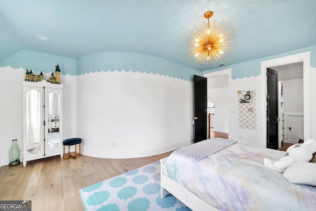 bedroom featuring an inviting chandelier, wood-type flooring, and vaulted ceiling