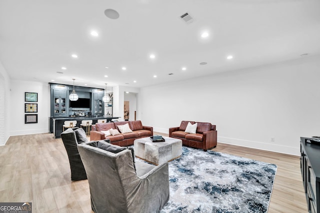 living room featuring crown molding and light hardwood / wood-style floors