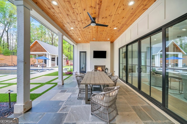 view of patio / terrace with a large fireplace and ceiling fan