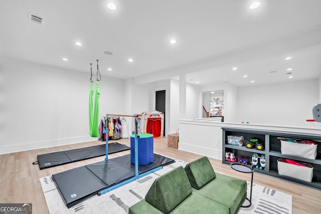 workout area with light hardwood / wood-style flooring