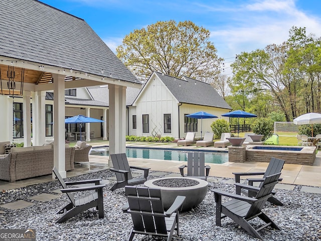 view of swimming pool with a patio and an outdoor living space with a fire pit