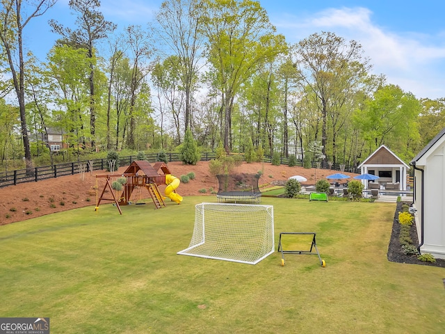 view of yard featuring a playground and a trampoline