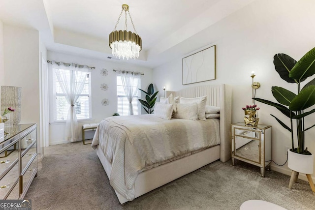 bedroom featuring light carpet, a chandelier, and a tray ceiling