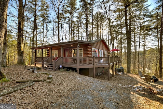 view of front facade featuring a wooden deck and a fire pit