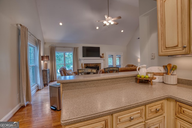 kitchen featuring ceiling fan, light brown cabinets, high vaulted ceiling, and light hardwood / wood-style flooring