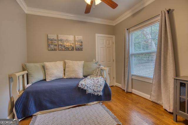 bedroom with crown molding, ceiling fan, and wood-type flooring