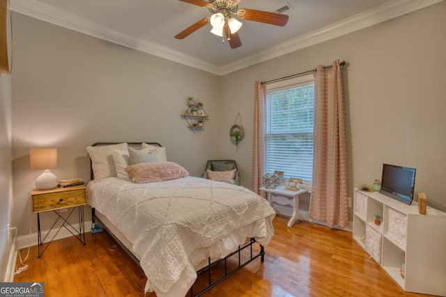 bedroom featuring ceiling fan, ornamental molding, and hardwood / wood-style floors