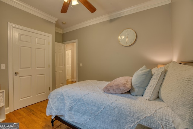 bedroom featuring wood-type flooring, ceiling fan, and crown molding