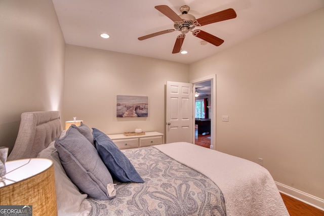 bedroom with dark hardwood / wood-style flooring and ceiling fan