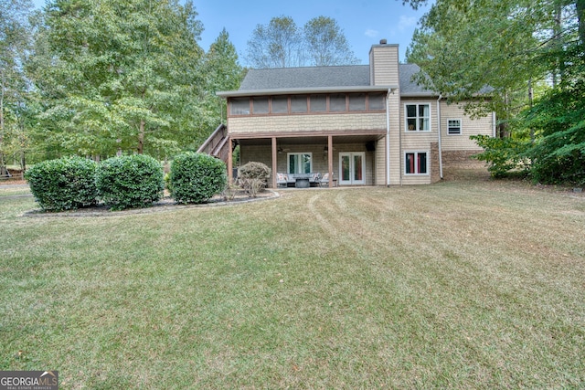 back of property featuring a yard and a sunroom