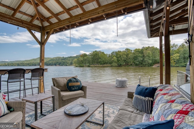 dock area with a gazebo, a water view, and an outdoor hangout area