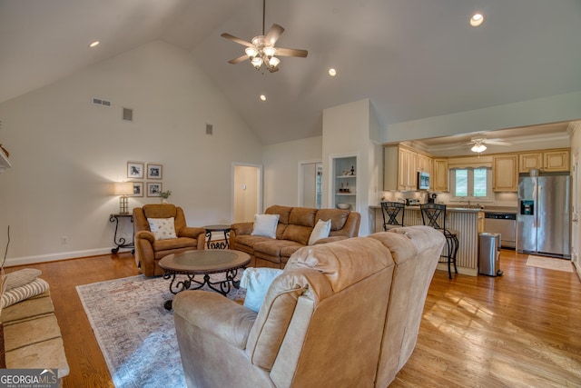 living room featuring ceiling fan, sink, high vaulted ceiling, and light hardwood / wood-style flooring