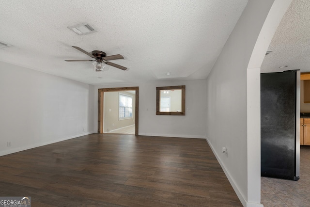 unfurnished living room with dark hardwood / wood-style flooring, a textured ceiling, and ceiling fan