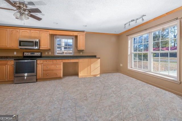 kitchen with light tile patterned floors, appliances with stainless steel finishes, built in desk, ornamental molding, and a textured ceiling