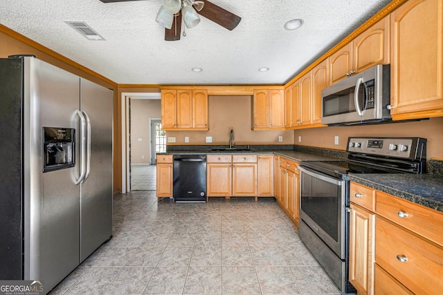 kitchen with light tile patterned flooring, appliances with stainless steel finishes, sink, and a textured ceiling