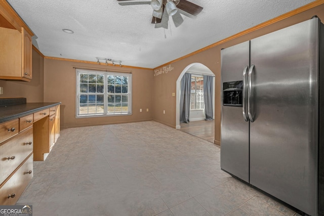 kitchen with stainless steel fridge with ice dispenser, crown molding, and a textured ceiling