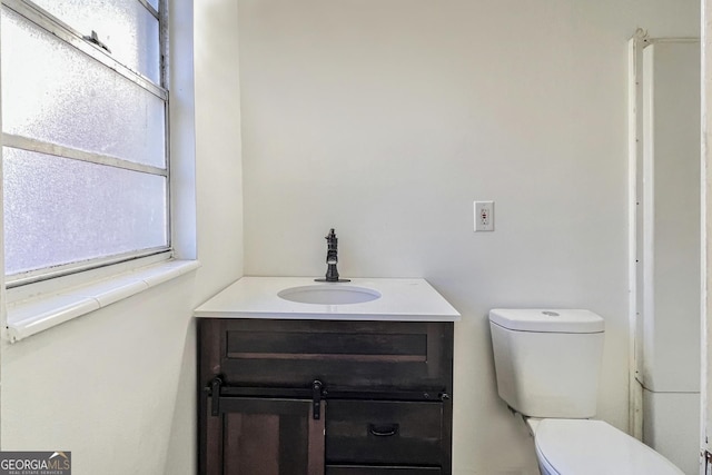 bathroom with vanity, a wealth of natural light, and toilet