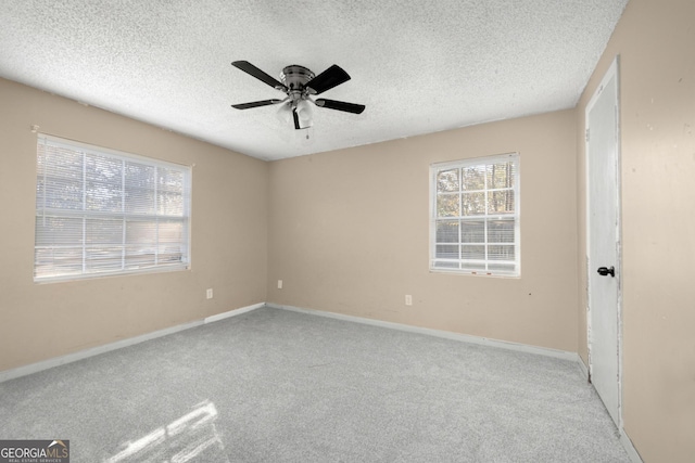 carpeted empty room featuring ceiling fan and a textured ceiling