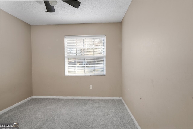 carpeted empty room with ceiling fan and a textured ceiling