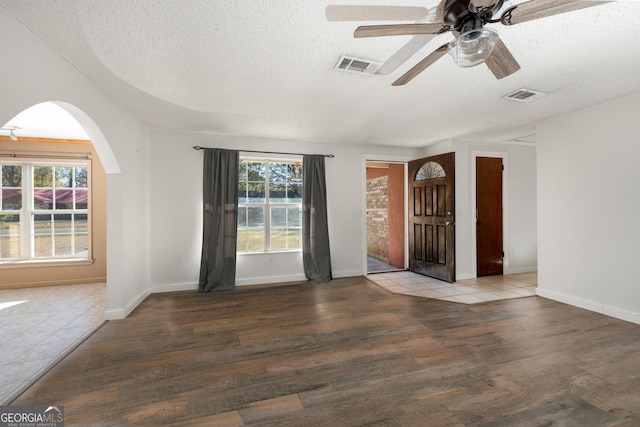 empty room featuring hardwood / wood-style flooring, ceiling fan, plenty of natural light, and a textured ceiling