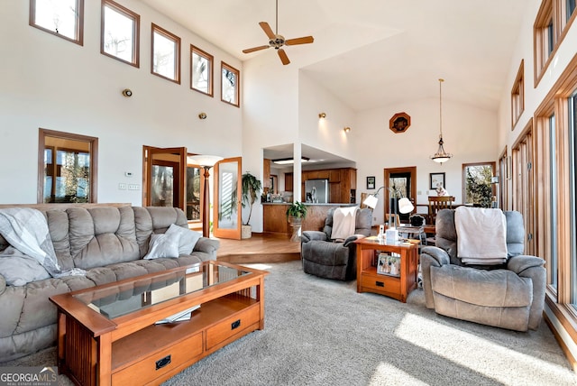 carpeted living room with ceiling fan, high vaulted ceiling, and a wealth of natural light