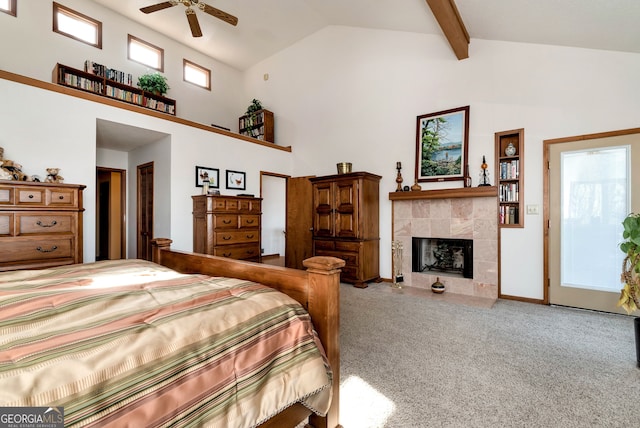 bedroom featuring beam ceiling, high vaulted ceiling, a tile fireplace, and carpet