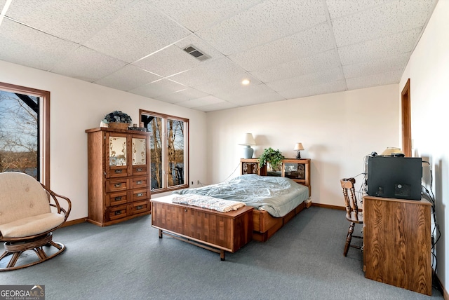 bedroom featuring a paneled ceiling and dark carpet