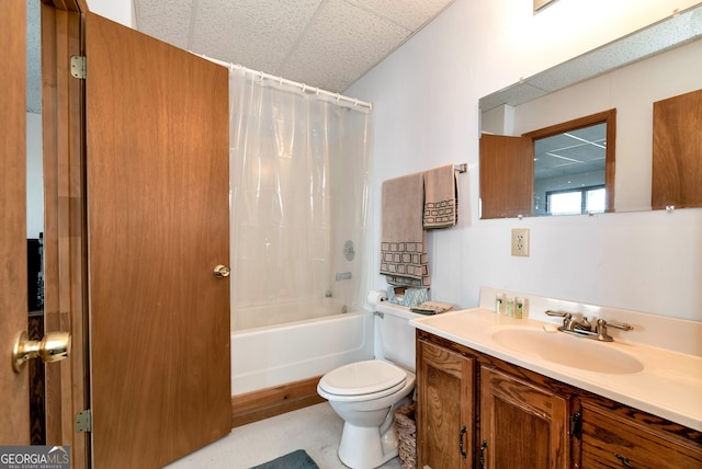 full bathroom featuring toilet, a paneled ceiling, vanity, and shower / bathtub combination with curtain