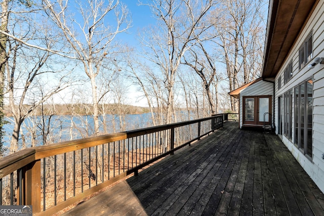 wooden terrace featuring a water view and french doors